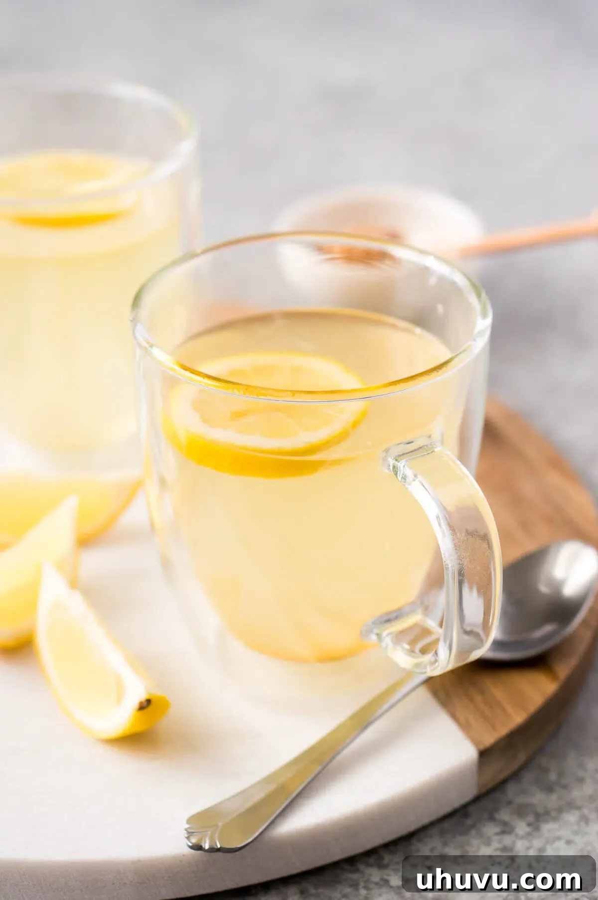 Finished lemon tea with honey in a glass cup, ready to be enjoyed.