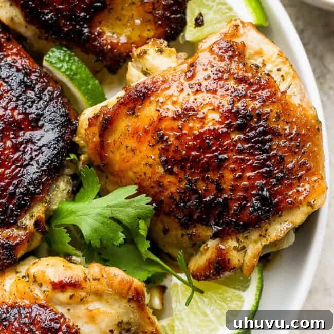 Cilantro Lime Chicken with a golden crispy skin on a plate, garnished with fresh herbs.