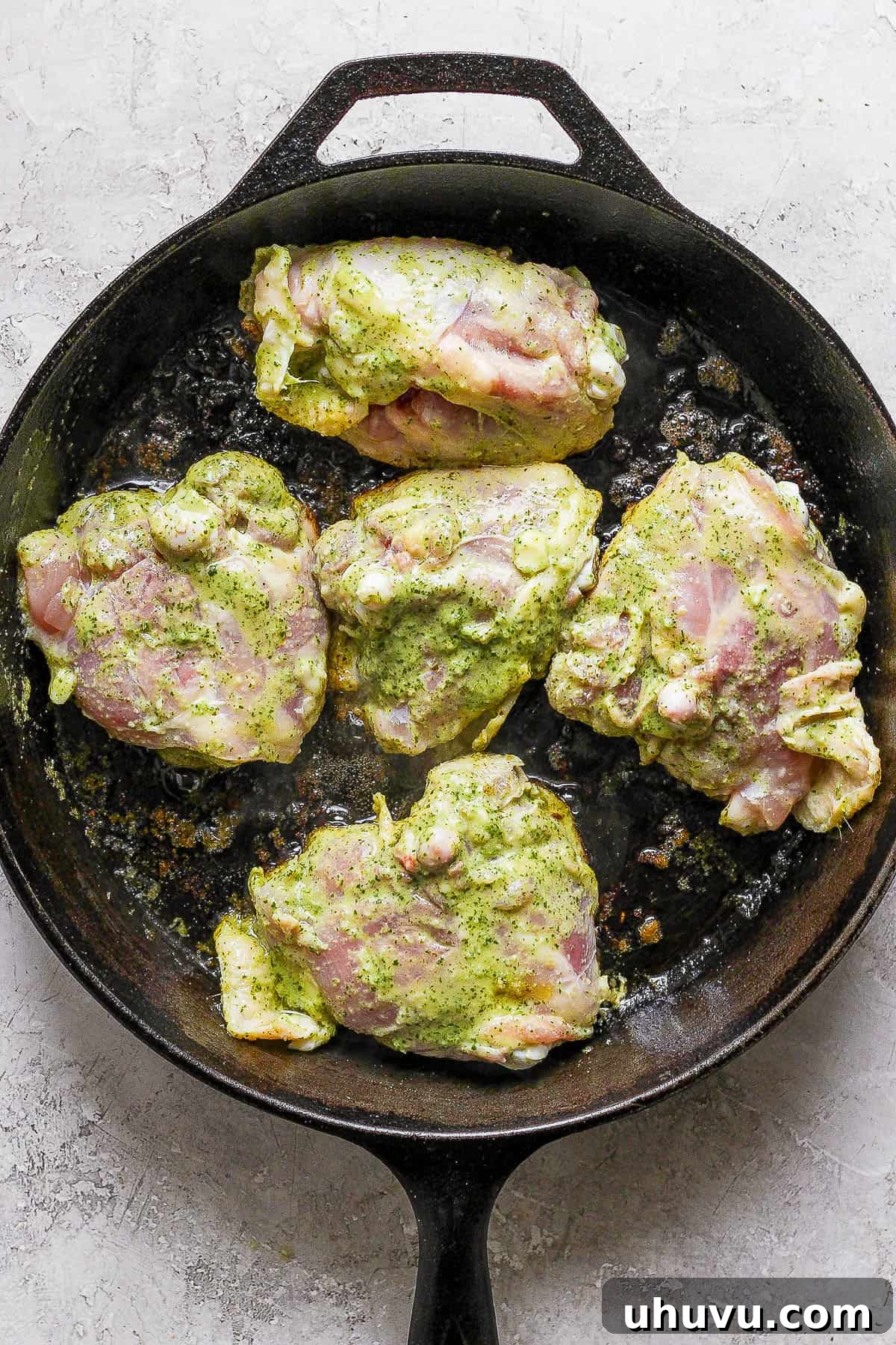 Zesty Cilantro Lime Chicken 8 Cilantro lime chicken thighs searing in an oven-safe skillet, skin-side down, to achieve a perfect golden crisp.