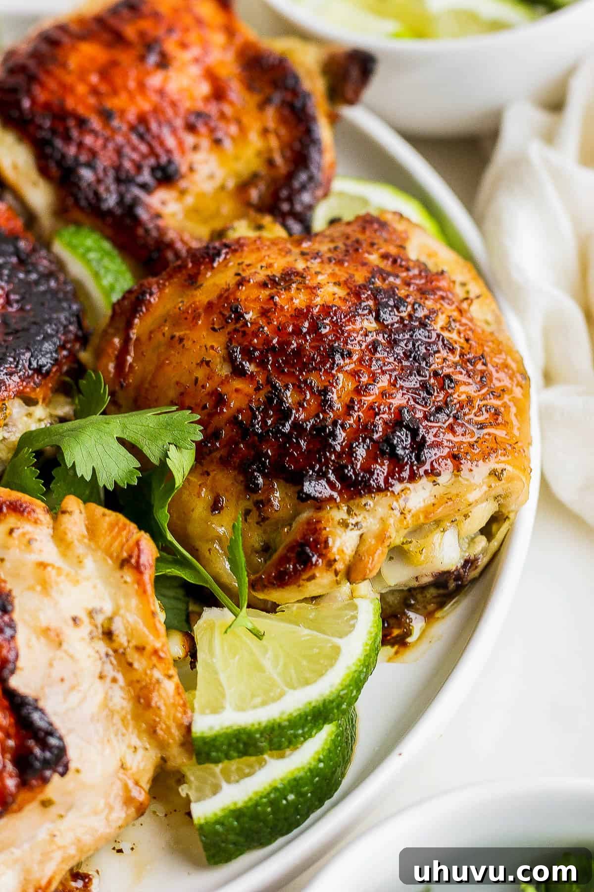 Zesty Cilantro Lime Chicken 10 A plate of juicy and tender cilantro lime chicken, adorned with perfectly crispy, golden-brown skin, garnished with fresh cilantro and lime wedges, ready to be served.