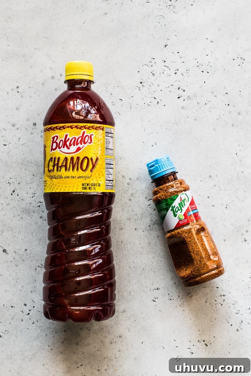 Chili-Lime Fruit Cups 4 A bottle of Bokados Chamoy Sauce and Tajin Clasico chile lime seasoning, essential condiments for authentic Mexican Fruit Cups.