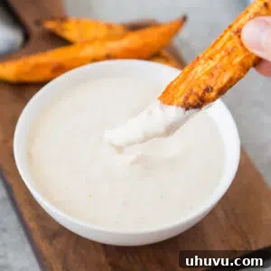 dipping baked potato wedge in garlic aioli sauce