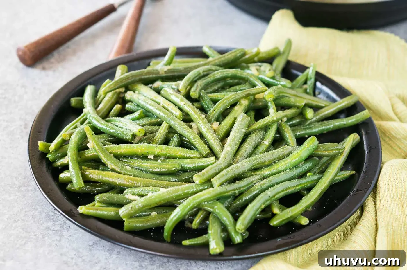 close up image of seasoned cooked green beans on a plate