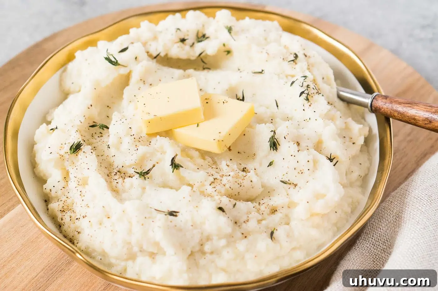 Close-up of fluffy and creamy mashed cauliflower with garlic, served in a bowl.