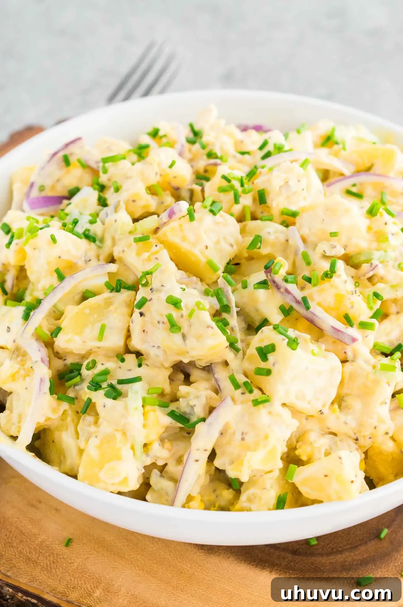 An easy potato salad with mayo and mustard, ready to be served in a bowl, perfect for a 4th of July celebration or summer potluck.