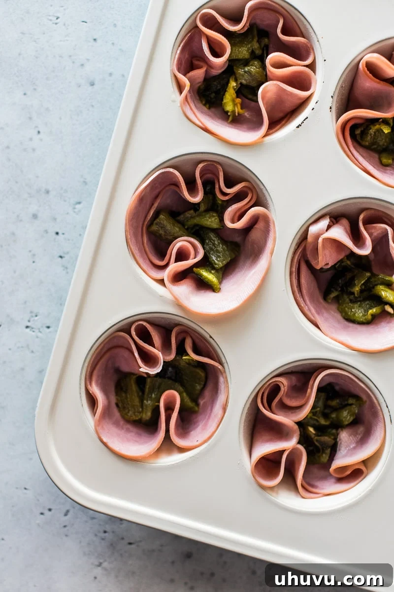 Poblano and Ham Egg Bake 3 Deli ham slices and chopped roasted poblanos in muffin tin cups.