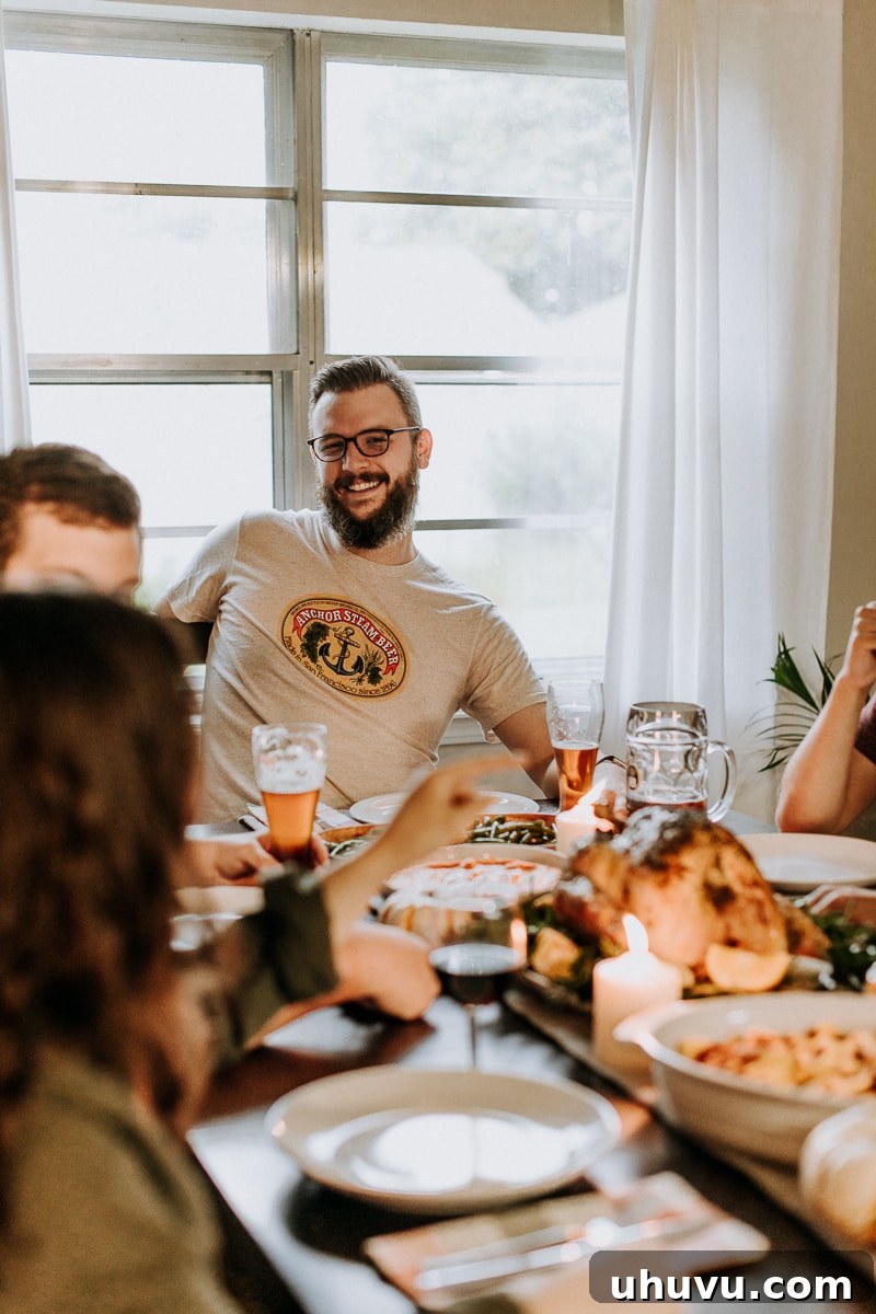 Friendsgiving Fun: Tips, Tricks, and Treats 11 A group of friends happily enjoying themselves around a festive table set for a Friendsgiving celebration.