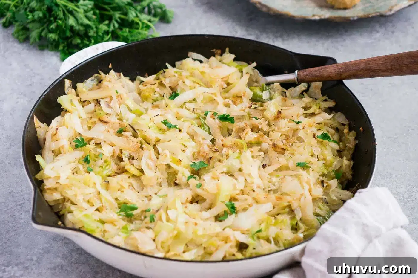 Cooked, golden-brown cabbage in a black skillet on a stovetop.