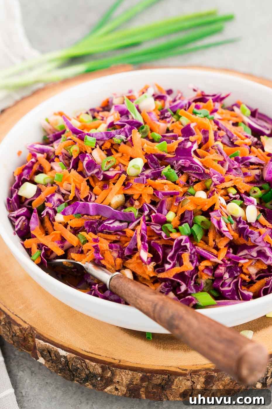 Crimson Cabbage Crunch 2 A large bowl filled with vibrant red cabbage and carrot slaw, garnished with fresh herbs, ready to serve.