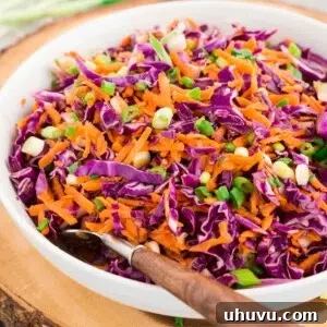 A top-down shot of a bowl of vibrant red cabbage slaw with shredded carrots, a perfect side dish.