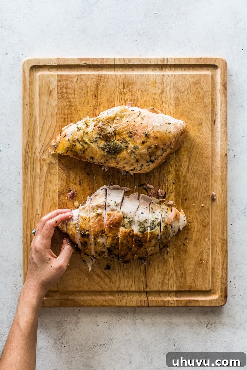 Two large, beautifully roasted turkey breasts, expertly sliced into uniform pieces and arranged on a cutting board, proudly displaying tender white meat.