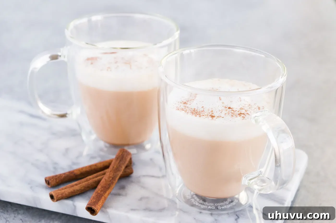 Homemade chai tea latte topped with milk foam in glass cups