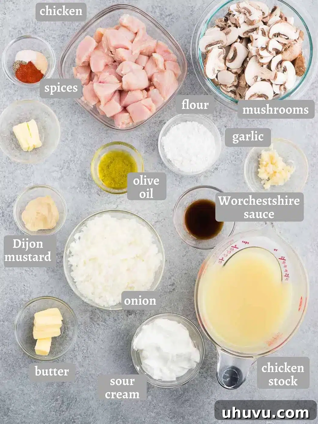 All the fresh ingredients for homemade chicken stroganoff recipe laid out on a rustic wooden board, ready for cooking.