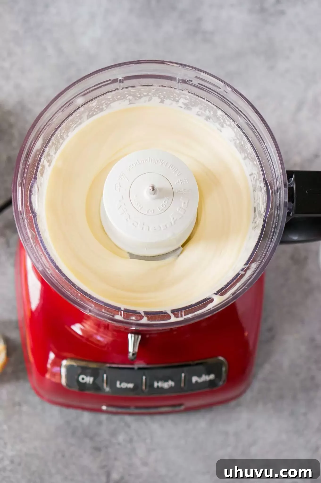 Homemade mayonnaise being perfectly blended in a food processor to a thick, creamy consistency.