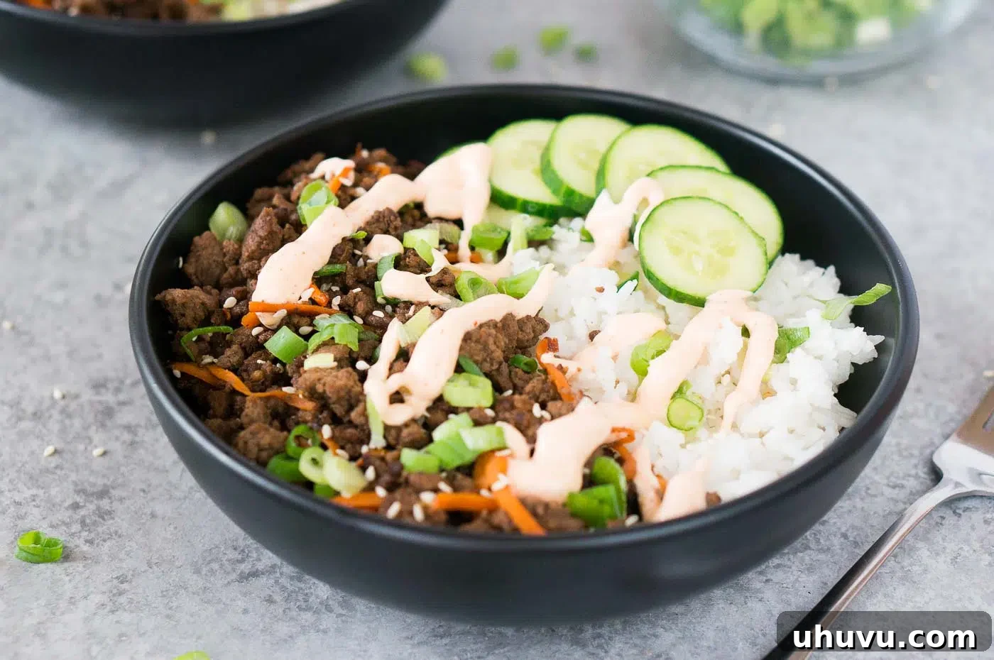 Beautifully arranged Korean beef bowl with glossy sauce, rice, and fresh garnishes