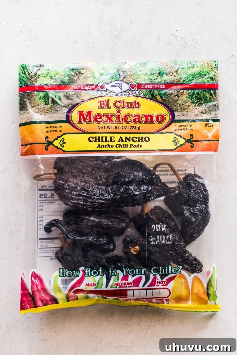 Smoky Sweet Anchos 3 A transparent bag filled with numerous dried ancho chile peppers, showcasing their characteristic wide, dark, and leathery appearance, ready for culinary use.