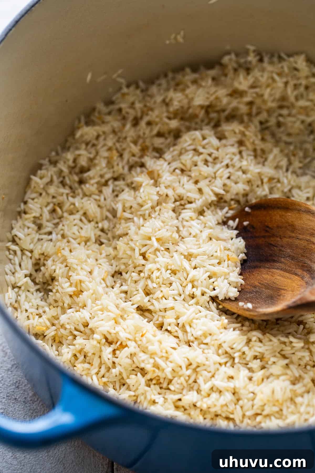 Zesty Green Rice 6 Long grain white rice being toasted in olive oil in a pot, developing a light golden hue for Arroz Verde.