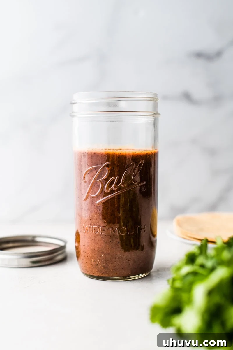 Easy homemade enchilada sauce stored in a clear glass jar.