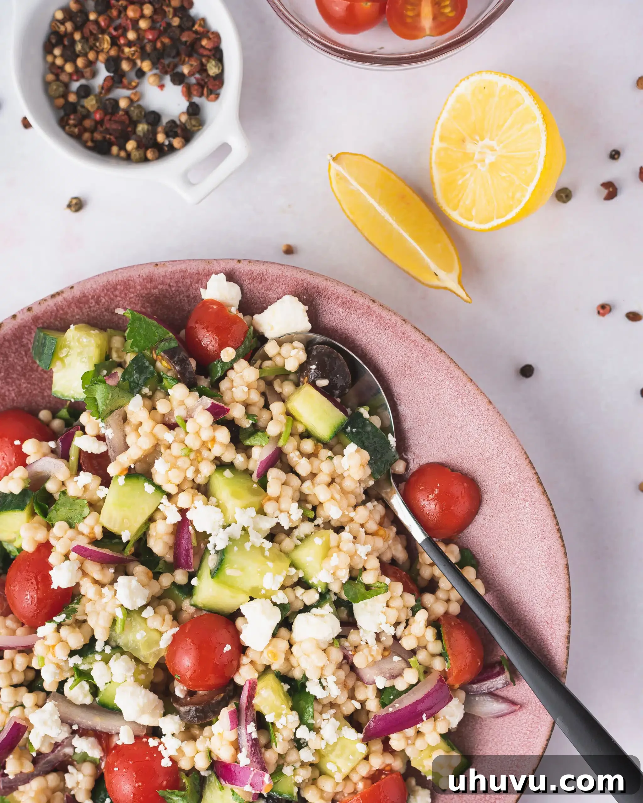 Plated Mediterranean pearl couscous salad with a vibrant mix of vegetables and herbs