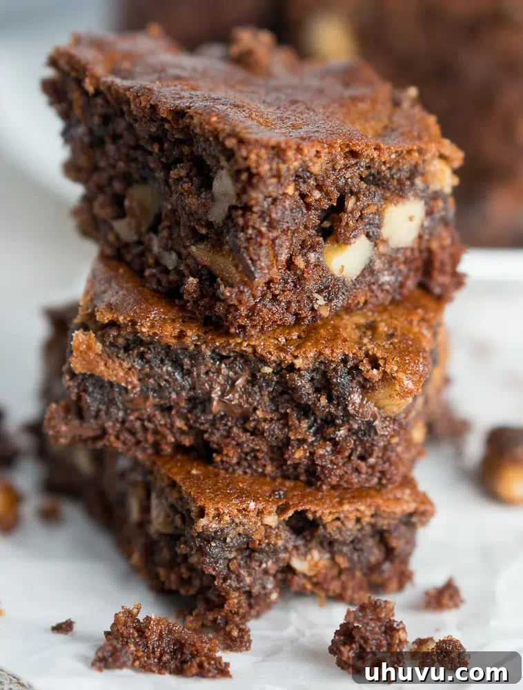 Close-up of freshly baked paleo almond butter brownies, showcasing the rich texture, melted chocolate chips, and chopped walnuts, ready to be enjoyed.