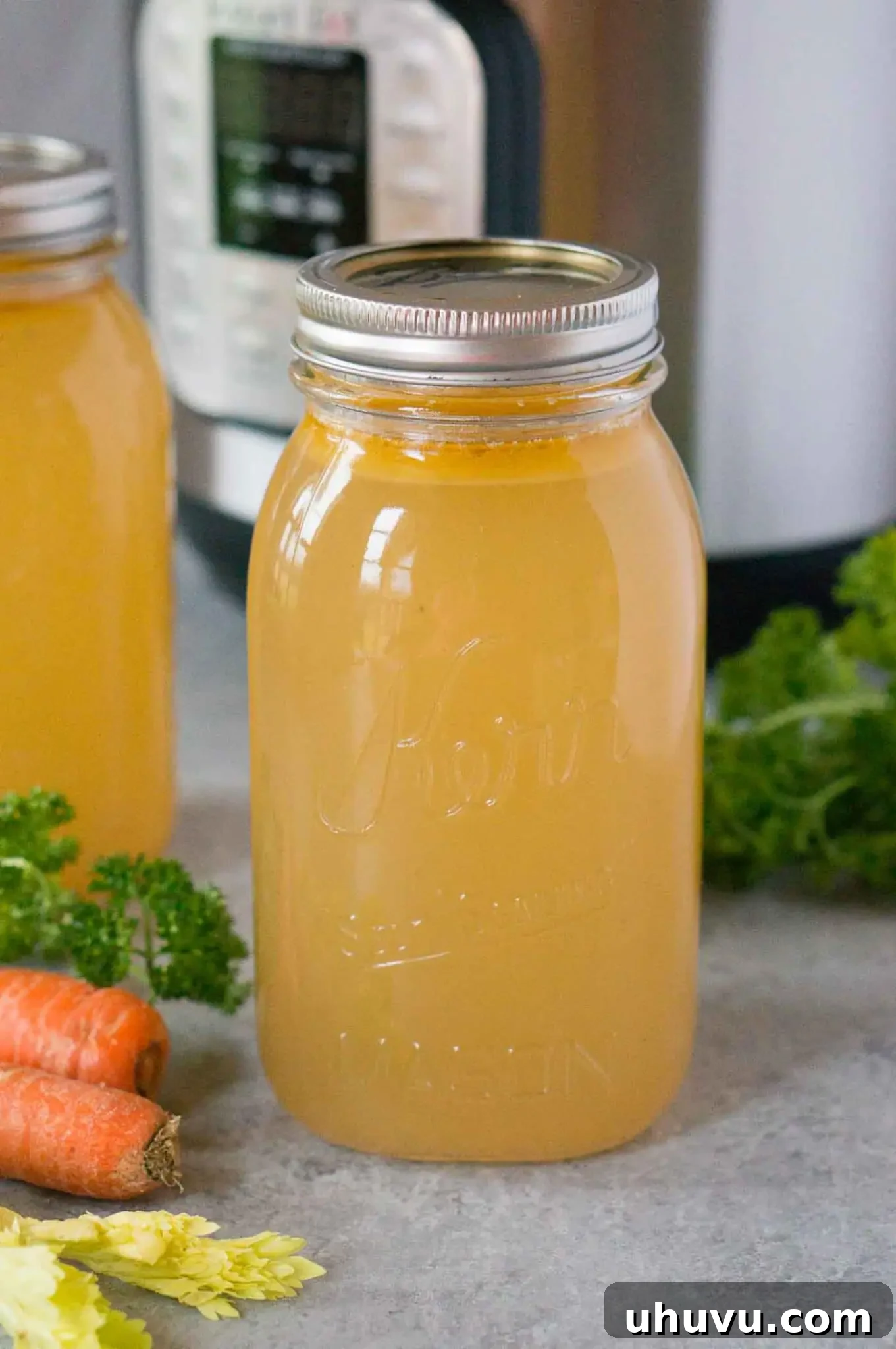 Instant pot chicken stock/broth in a jar, showcasing its golden color and richness