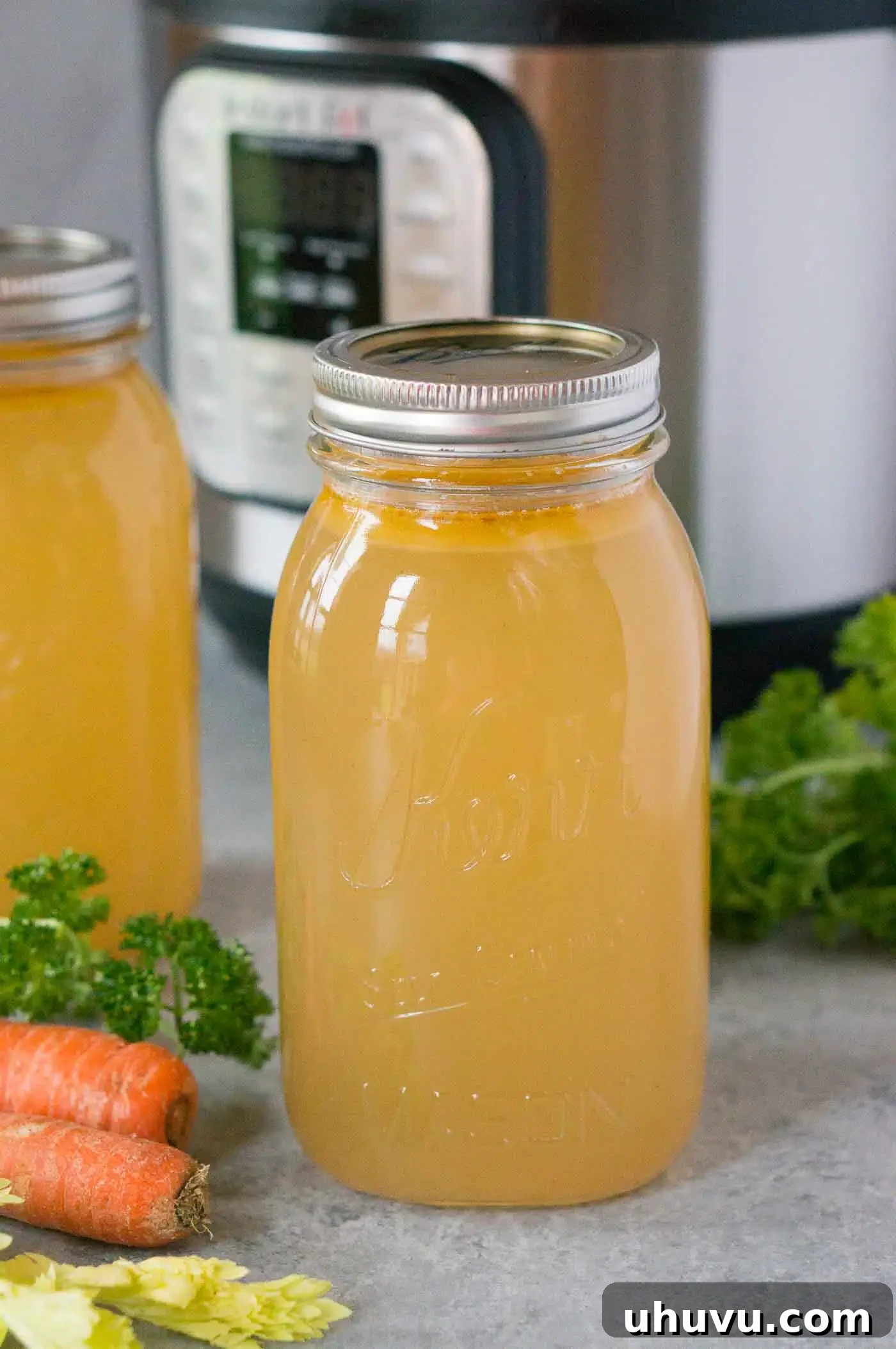 chicken stock in a jar with instant pot in background, emphasizing homemade goodness