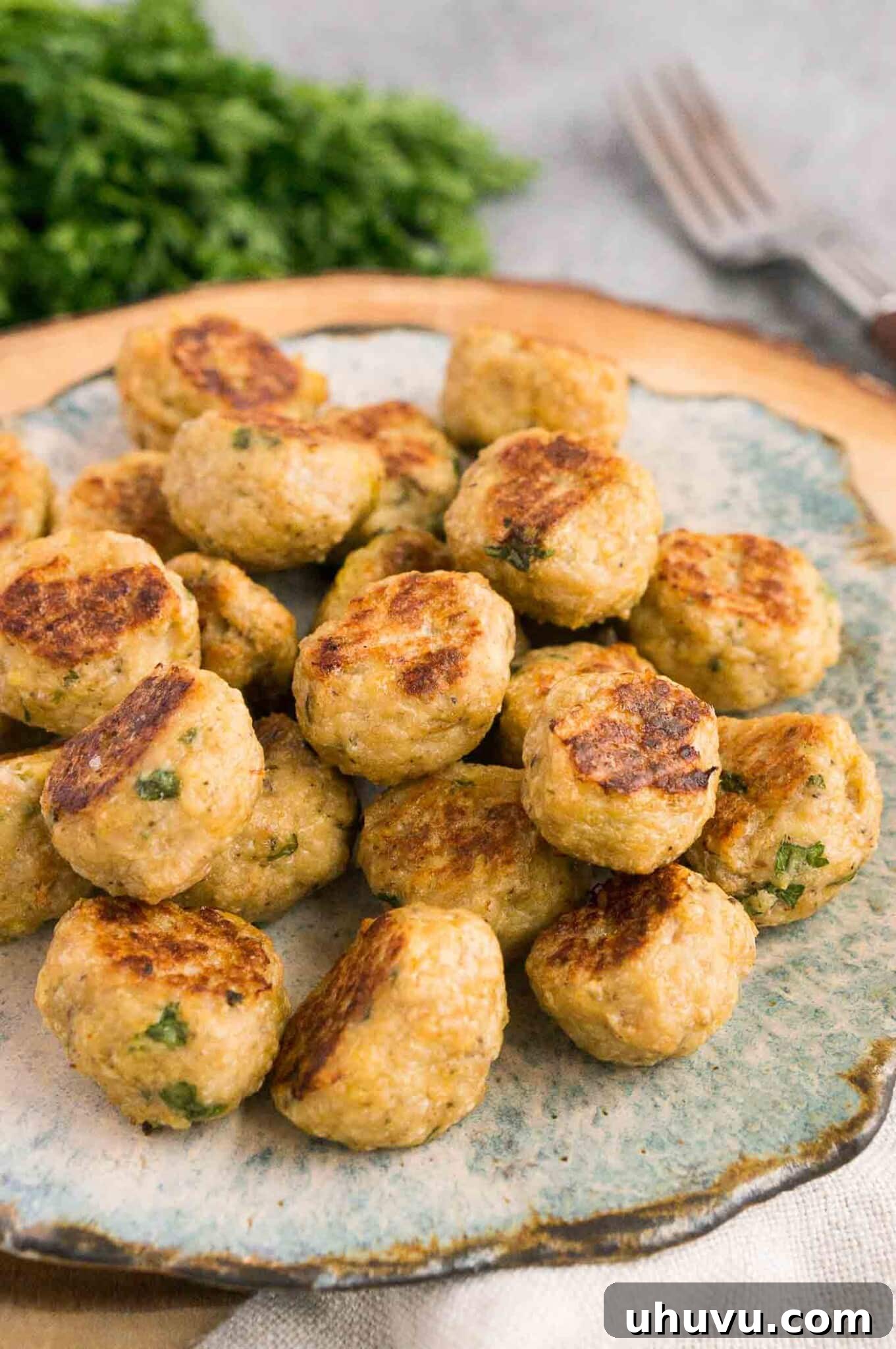 Savory Chicken Meatballs 6 healthy chicken meatballs on a plate with fresh greens
