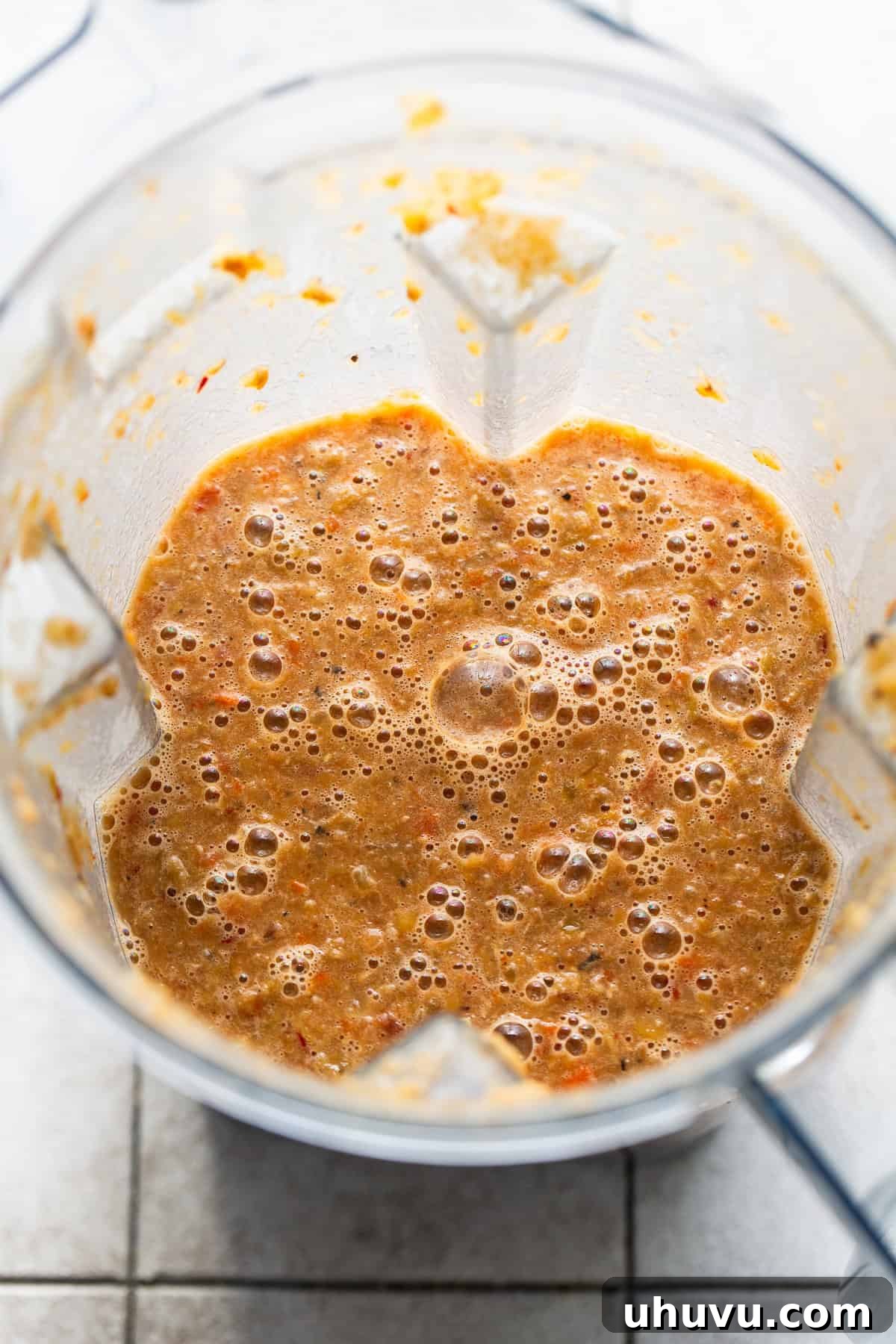 A portion of the soup being blended in a blender.