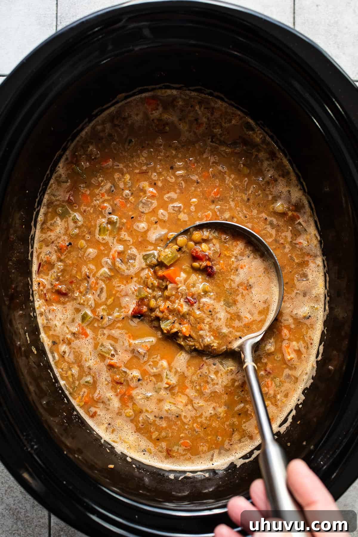 The finished soup in the slow cooker with a ladle, showing its rich texture.