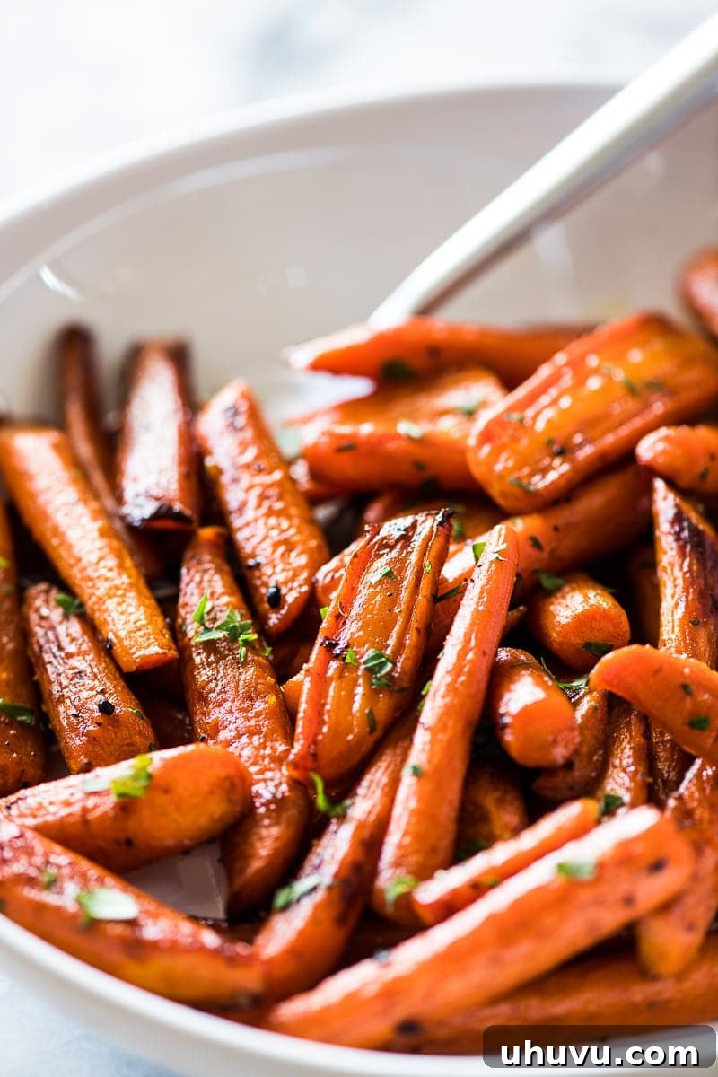 Glazed Maple Cinnamon Carrots 2 Oven roasted carrots topped with chopped parsley, showcasing their beautiful glaze and vibrant orange color.