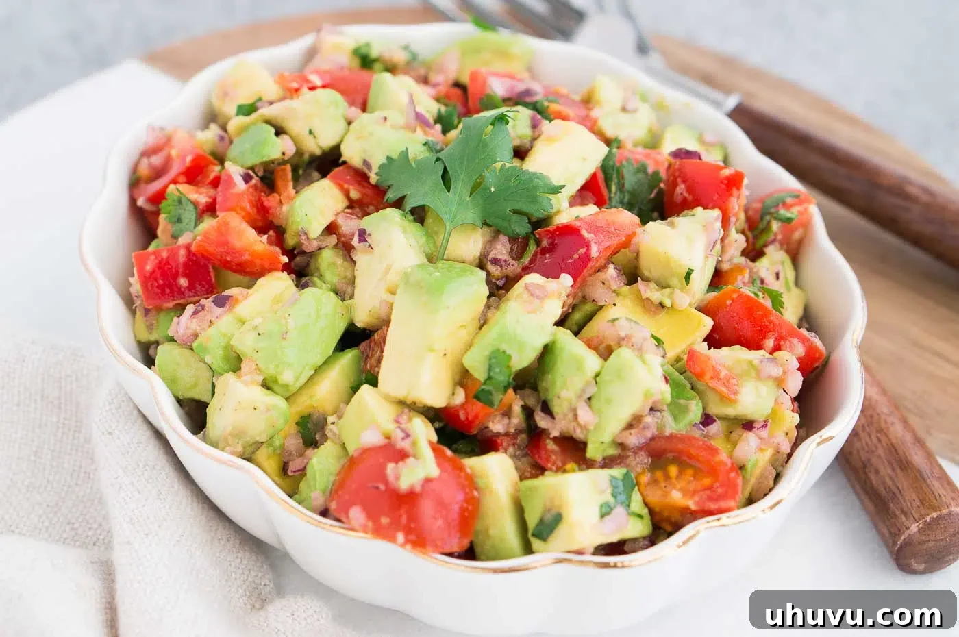 A close-up shot of avocado salsa in a bowl, showing the fresh ingredients