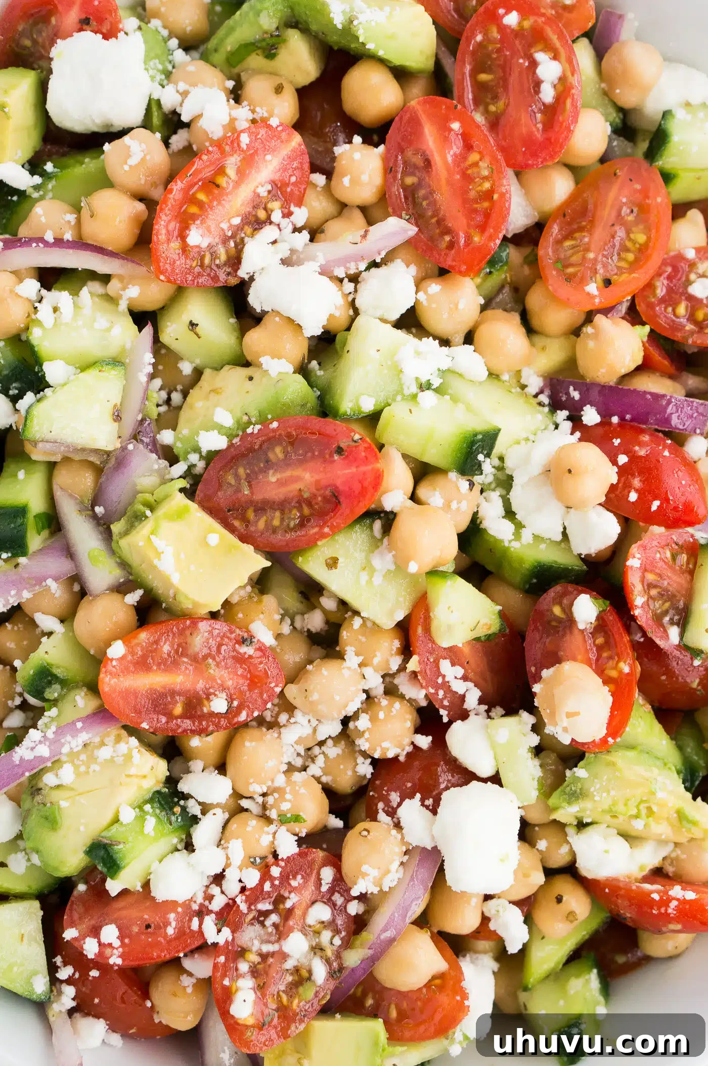 Close-up shot of a simple chickpea salad in a white bowl, showcasing its fresh ingredients and vibrant colors.