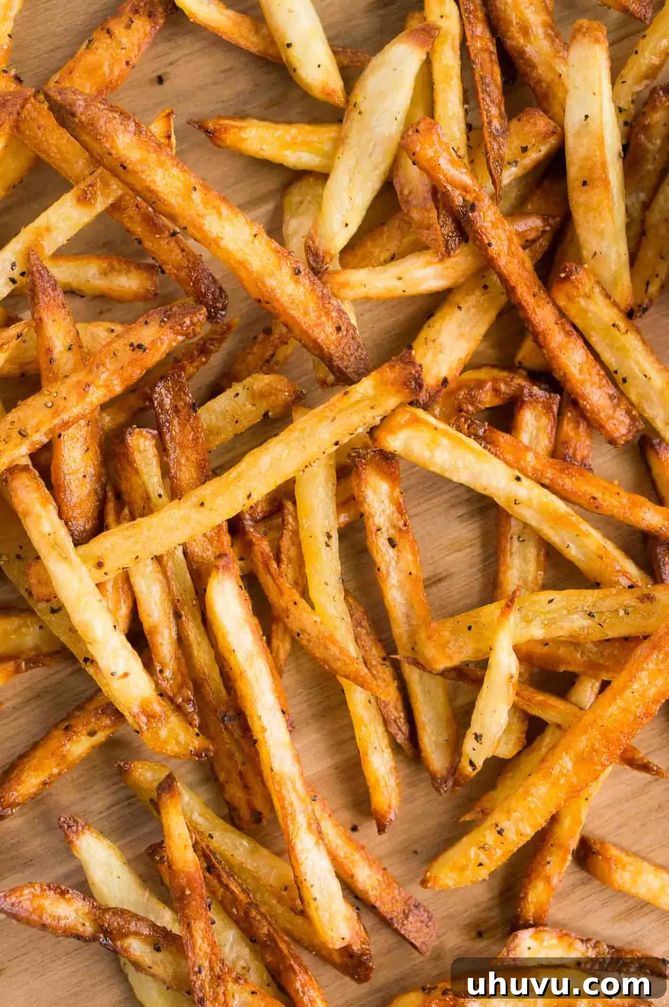 Oven-baked fries served on a wooden board