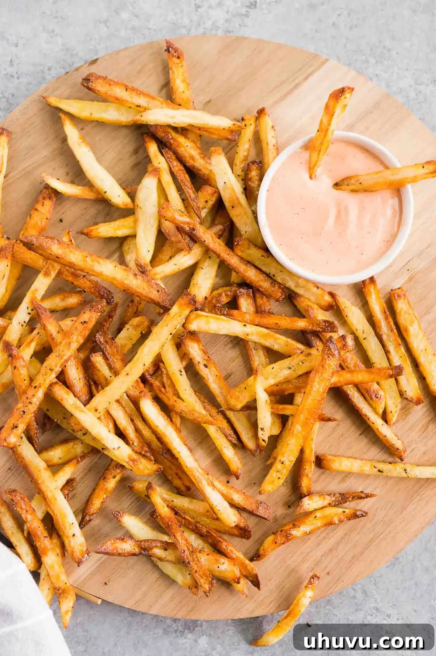 The best homemade french fries served on a wooden board with dipping sauce