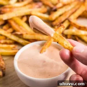 A small bowl of homemade fry sauce, showcasing its creamy texture against a backdrop of golden fries.