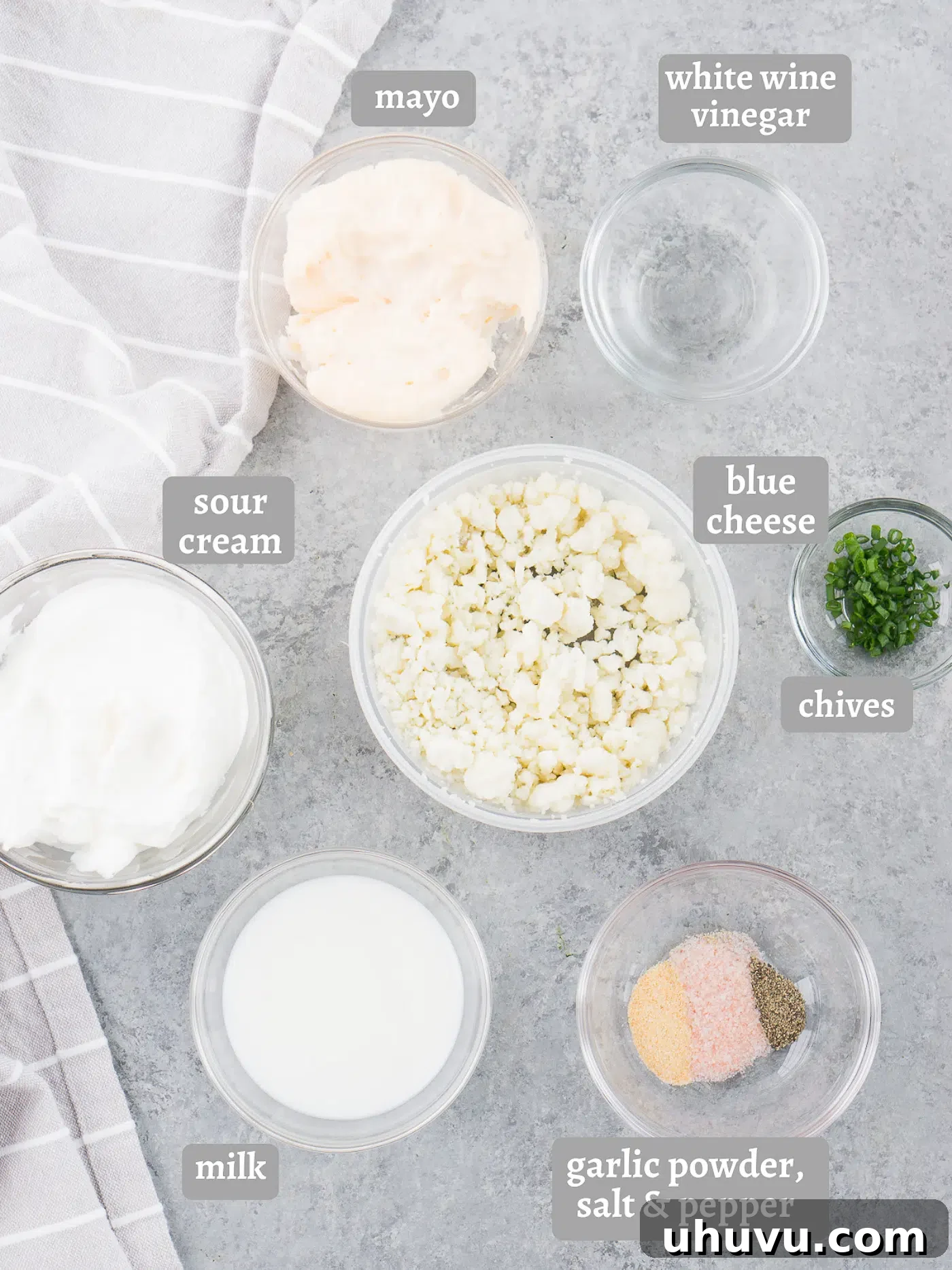 Various ingredients for blue cheese salad dressing laid out on a table