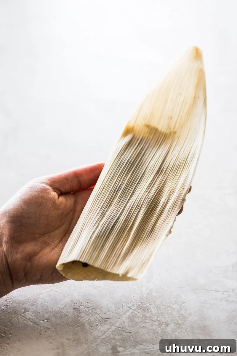 Unwrap the Flavor: Authentic Mexican Tamales 13 A corn husk folded in half, demonstrating the first step in wrapping a tamale.