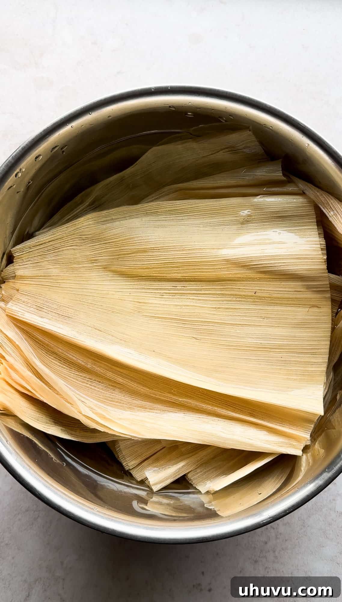 Unwrap the Flavor: Authentic Mexican Tamales 5 Corn husks soaking in a bowl of hot water, softening for tamale preparation.