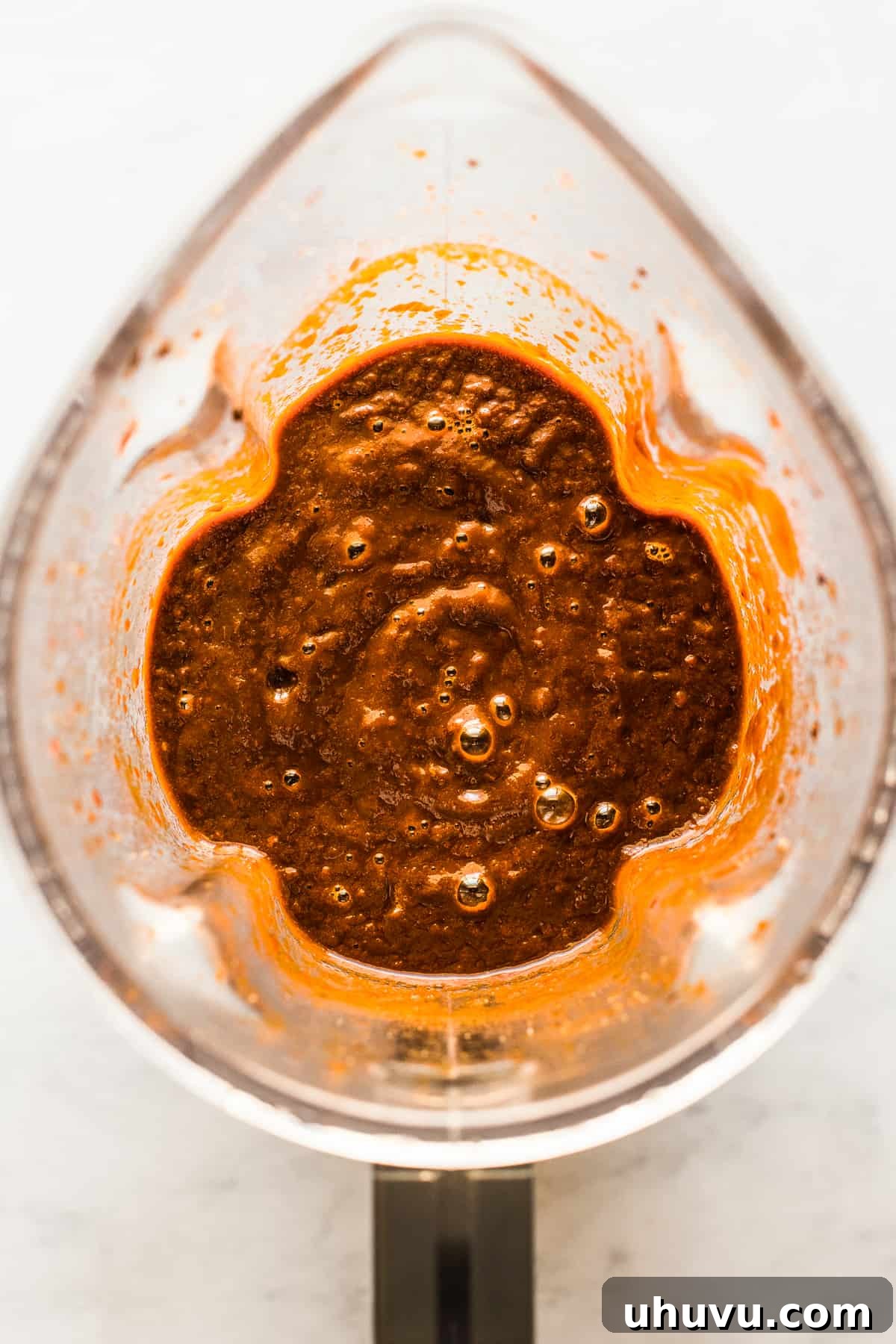 Unwrap the Flavor: Authentic Mexican Tamales 7 A vibrant, blended red chile sauce in a blender, perfectly smooth for tamale filling.