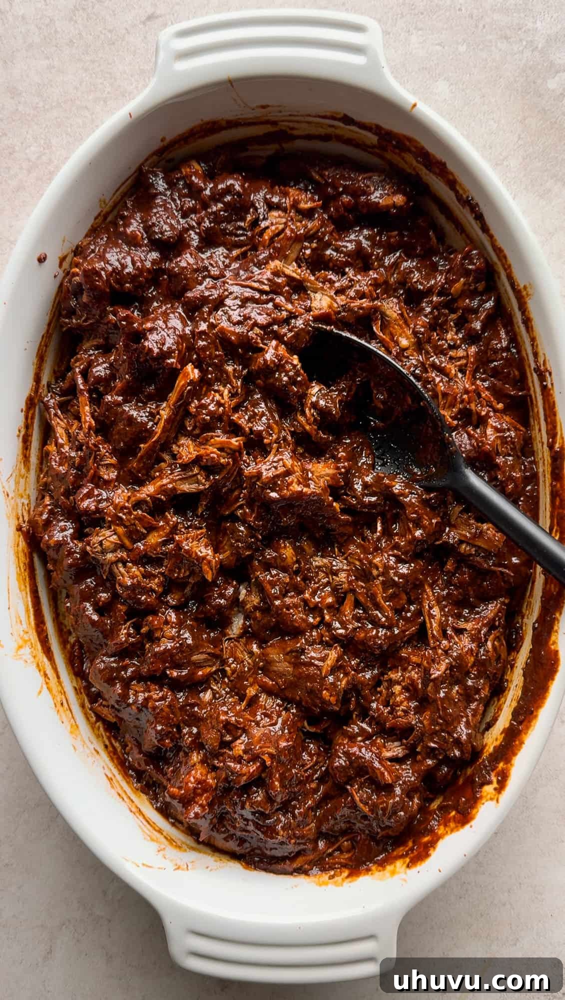 Unwrap the Flavor: Authentic Mexican Tamales 8 Tender shredded pork coated in a rich red chile sauce, ready for tamale filling.