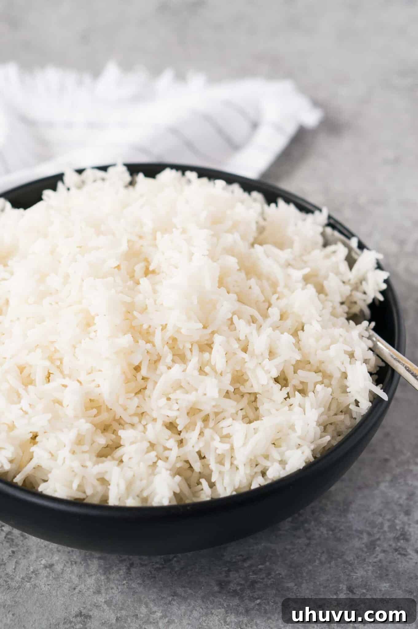 Pressure Cooker Rice Perfection 7 fluffy rice made in a instant pot served in a black bowl