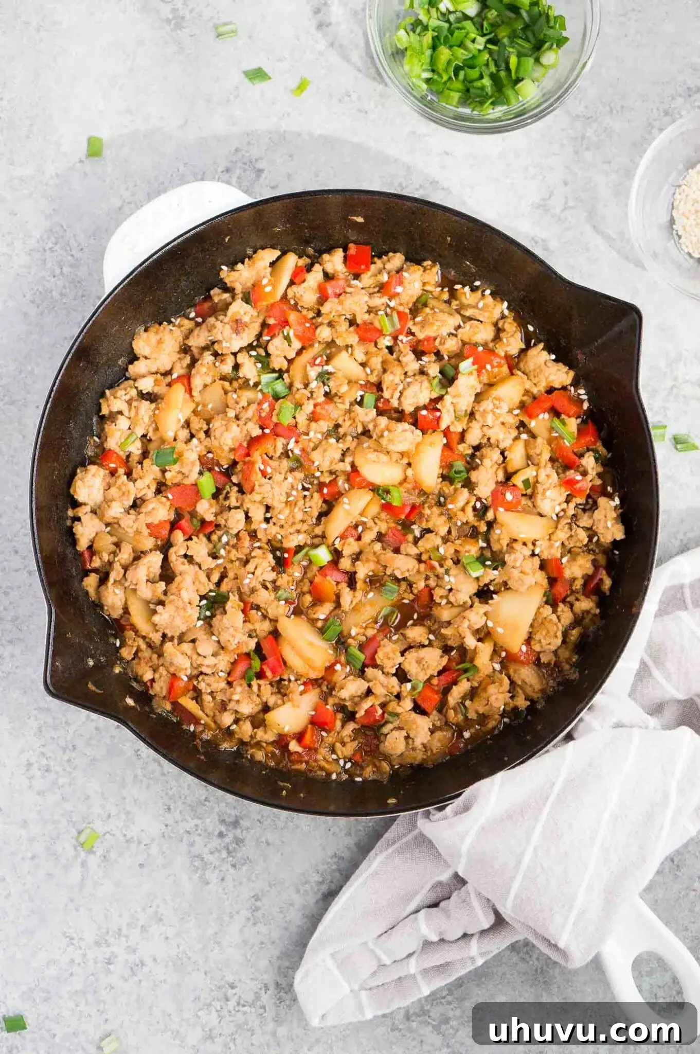 Ground chicken simmering in a rich, savory Asian sauce in a skillet