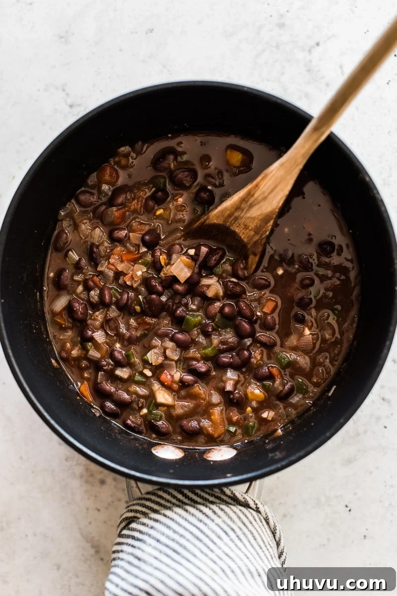 Elevating Canned Black Beans 3 A saucepan on the stove, showing the initial step of cooking canned black beans by sautéing aromatics and spices.