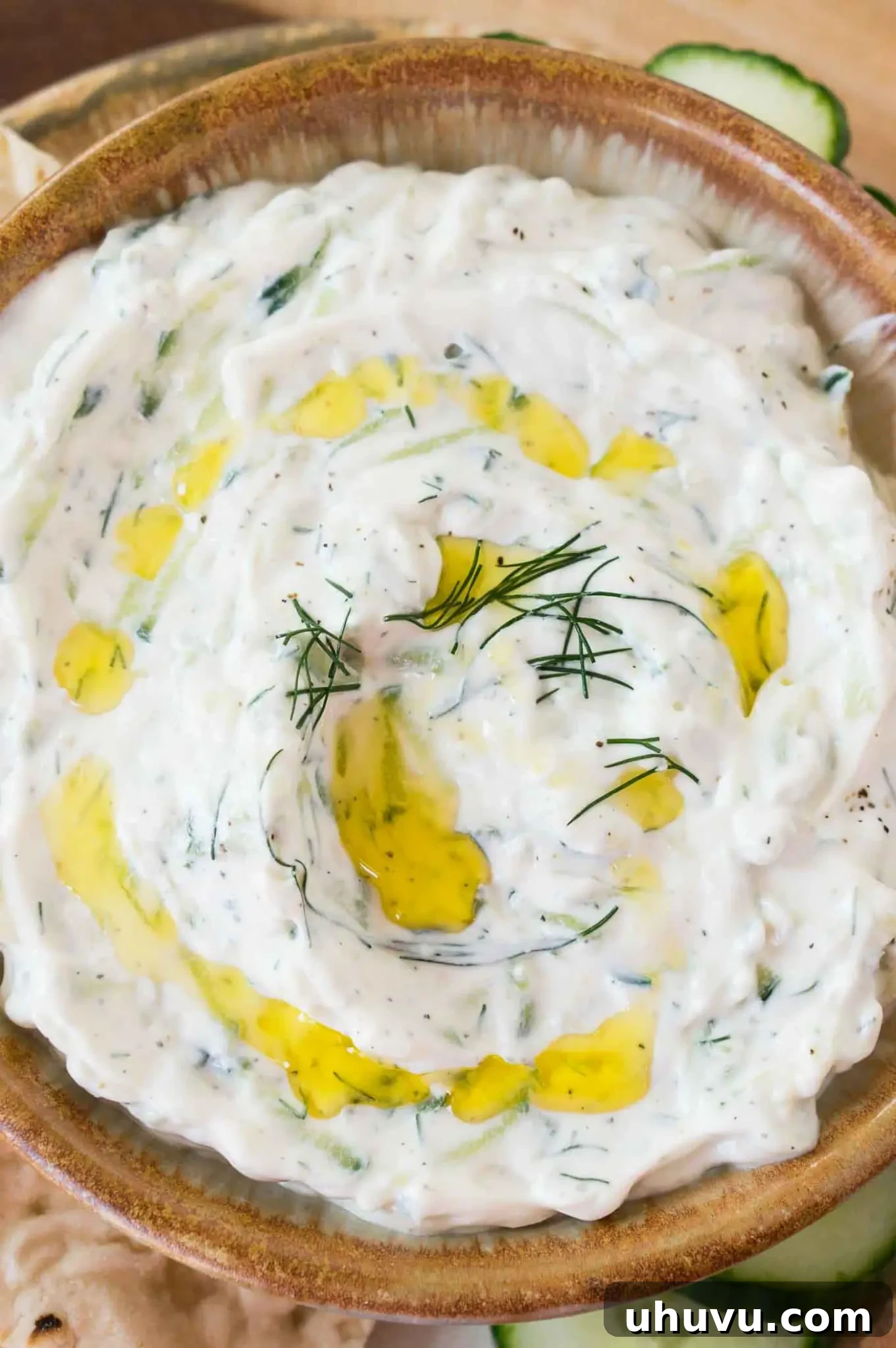 Zesty Greek Cucumber Sauce 6 Close-up of freshly prepared Tzatziki sauce, showcasing its creamy texture and visible cucumber bits, garnished with dill.