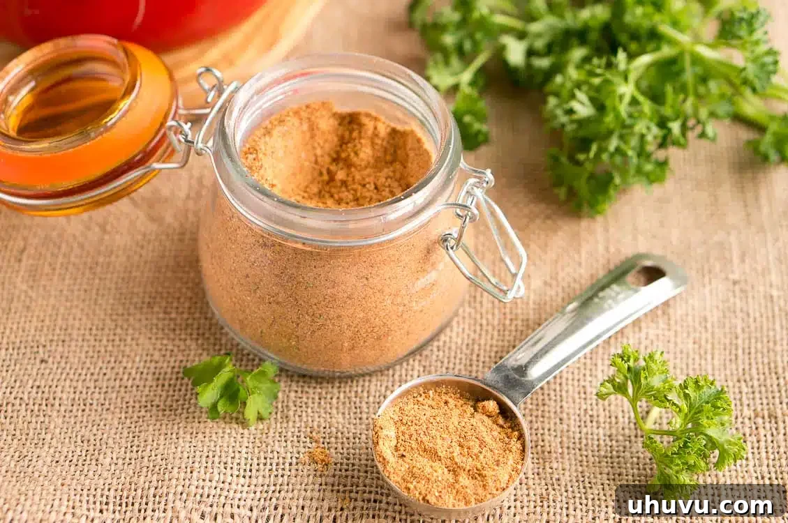 Ultimate Homemade Taco Spice Blend 3 A top-down view of various fresh spices, including chili powder, cumin, and paprika, laid out on a wooden surface for making homemade taco seasoning.