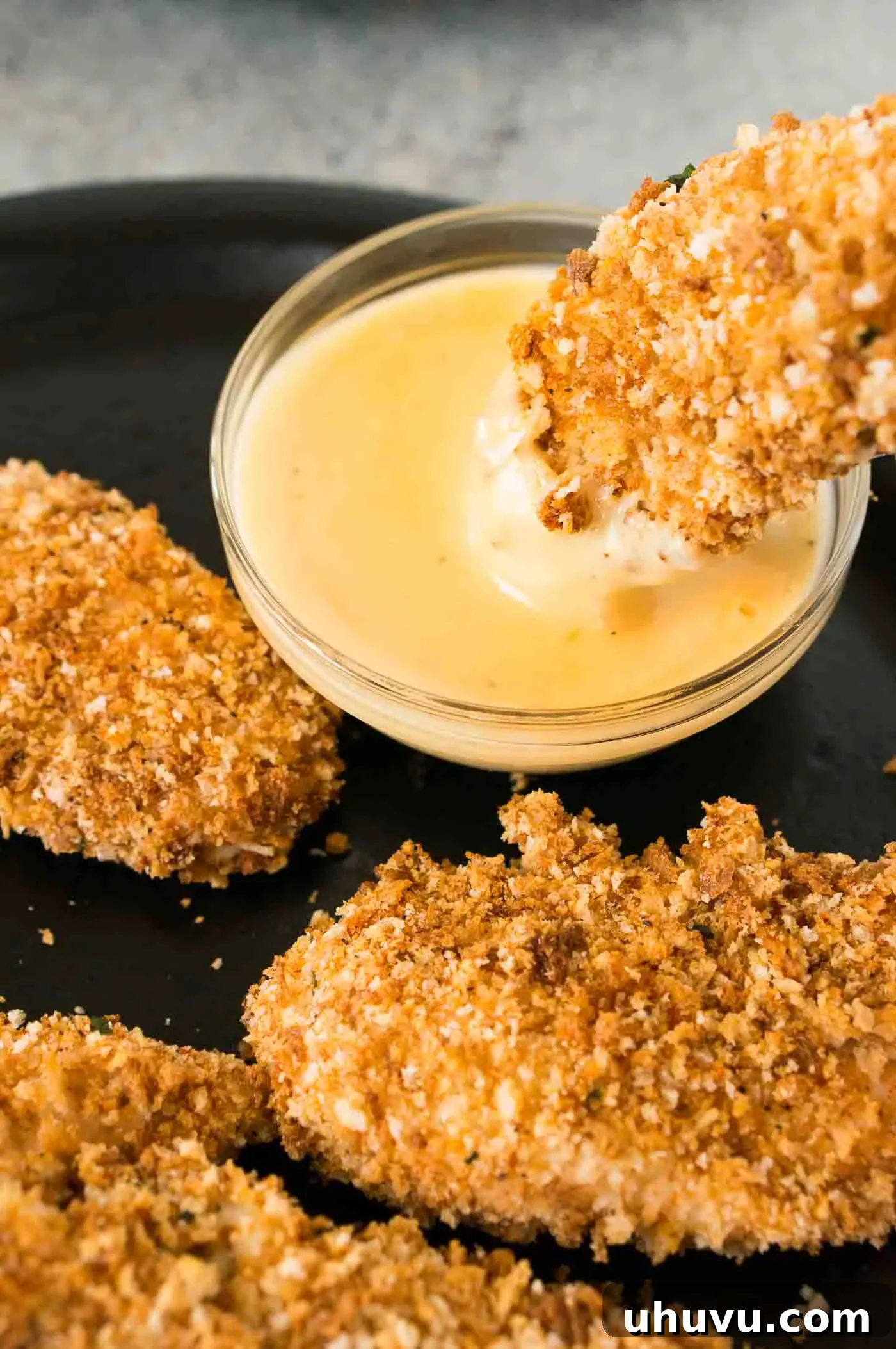 dipping chicken tenders in honey Dijon sauce