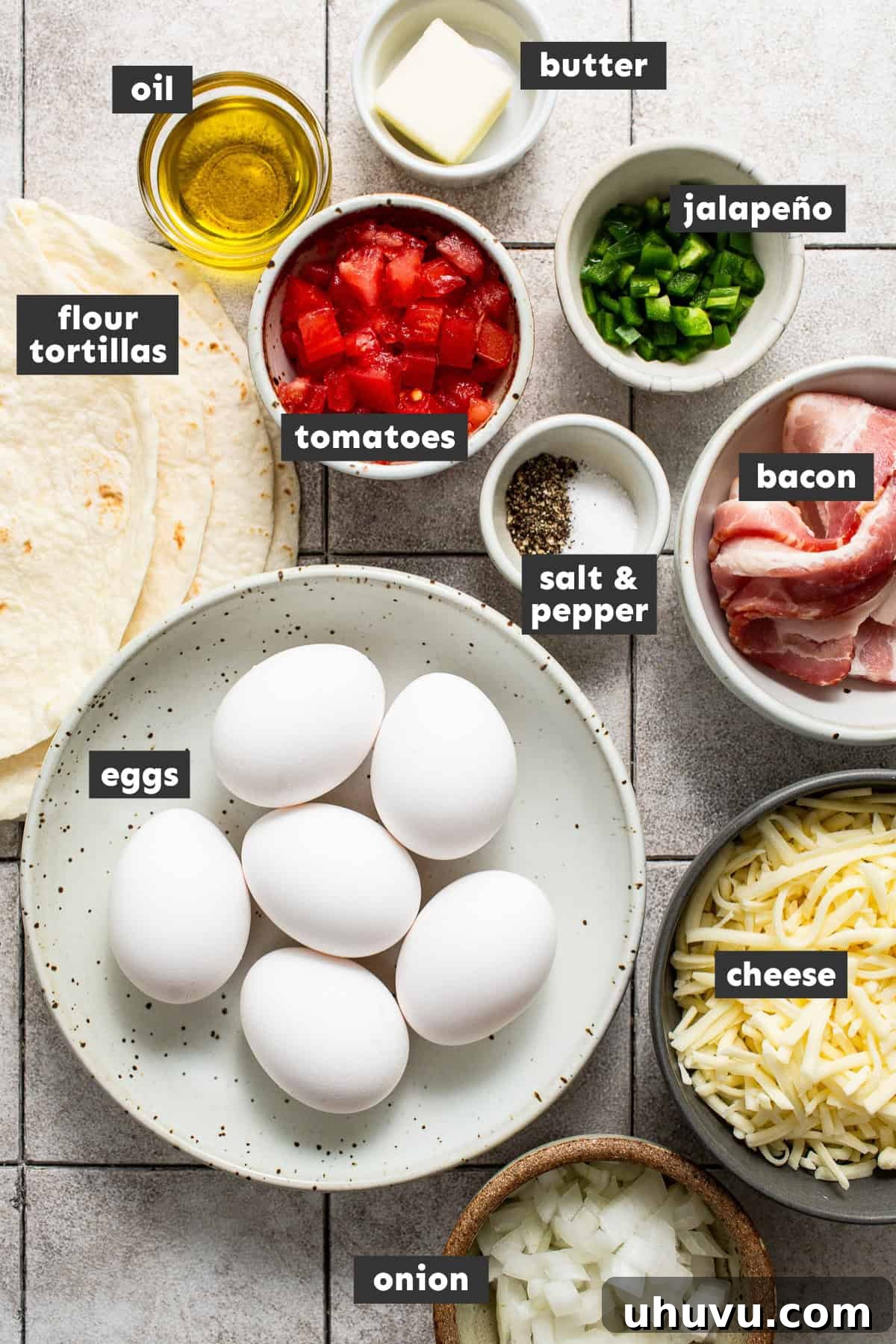 Savory Morning Quesadillas 3 Fresh ingredients for breakfast quesadillas laid out on a kitchen table, including eggs, bacon, tortillas, cheese, and a mix of onion, tomato, and jalapeño.