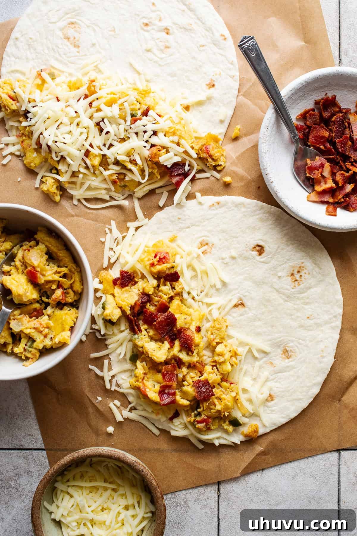 Savory Morning Quesadillas 5 A breakfast quesadilla being carefully assembled on a tortilla, layering shredded cheese, scrambled eggs, and crumbled cooked bacon.