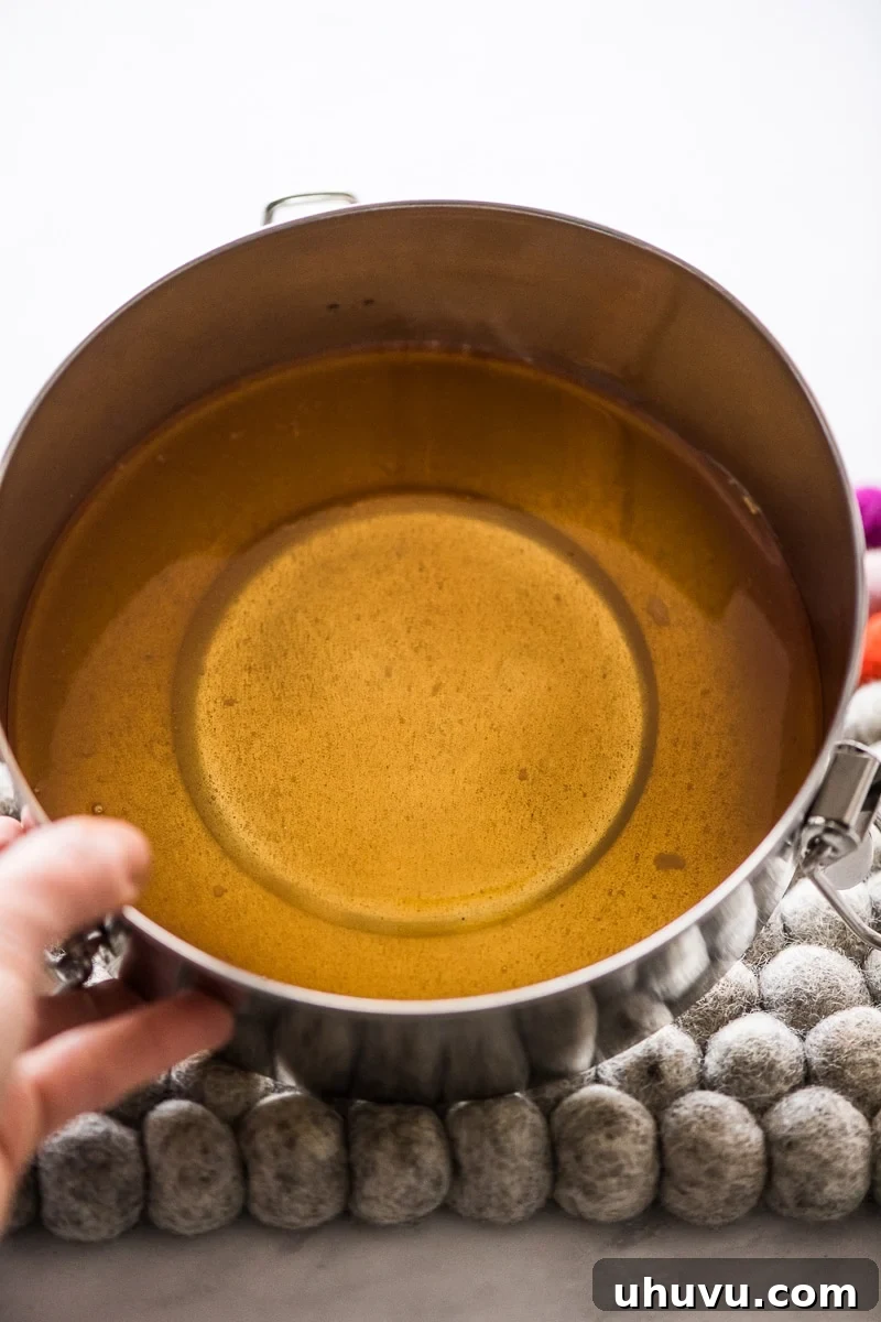 Simple Silky Flan Perfection 5 Molten caramel spread evenly across the bottom of a flan pan, forming the base of the dessert.