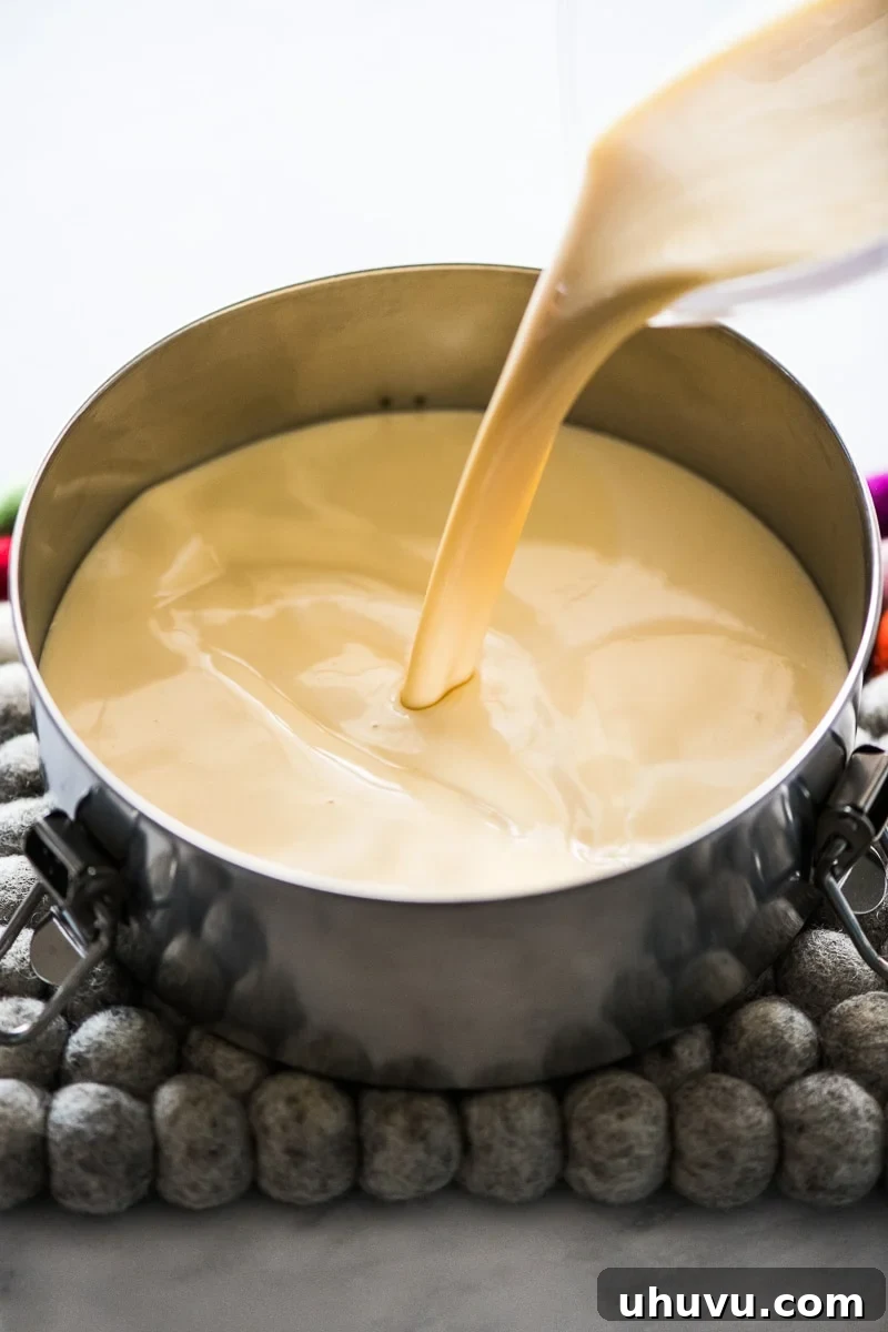 Simple Silky Flan Perfection 6 A creamy custard mixture being poured into a flan pan, layered over the hardened caramel base.